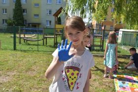 Dziewczynka pokazuje pomalowana na niebiesko dłoń