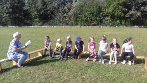 Dzieci siedząc na ławeczkach na zewnątrz